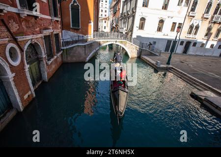 Venezia, Italia. I turisti che viaggiano in gondola in un canale esplorano la città di Venezia. Foto Stock