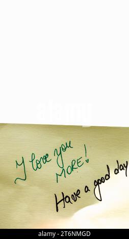 Ti amo più handwriting testo primo piano isolato su carta gialla con spazio di copia. Foto Stock