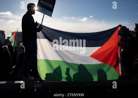 I manifestanti avanzano sul ponte Vauxhall durante la marcia pro-palestinese attraverso il centro di Londra, che ha coinciso con l'evento annuale della giornata dell'armistizio, l'11 novembre 2023. Tra le tensioni tra le comunità opposte e il giorno del lutto nazionale per la morte della guerra britannica, il Commissario della polizia MET, Sir Mark Rowley, si è scontrato sia con il Segretario di Stato Suella Braverman che con il primo Ministro Rishi Sunak, i quali si sono chiesti se la marcia contro gli attacchi israeliani a Gaza dovesse andare avanti a causa di possibili disordini pubblici. 300.000 mila hanno preso la strada concordata presa dai manifestanti Foto Stock
