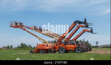 BEMIDJI, Minnesota - 3 giugno 2023: File di ascensori JLG parcheggiati e carrelli elevatori SkyTrak, con bracci idraulici. Foto Stock