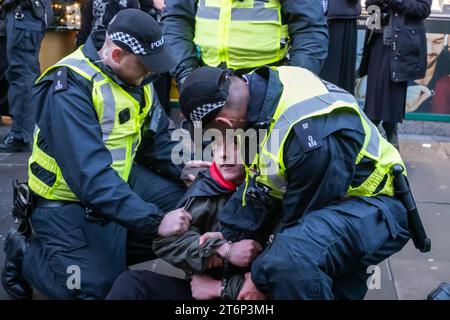 Glasgow, Scozia, Regno Unito. 11 novembre 2023. Nel giorno dell'armistizio, gli ufficiali di polizia scozzesi arrestano un sostenitore palestinese in Argyle Street mentre le persone che sostengono la Palestina partecipano a una manifestazione alle fasi di Buchanan per protestare contro il conflitto israelo-palestinese in corso e poi si dirigono in strada per marciare verso George Square. Credito: SKULLY/Alamy Live News Foto Stock