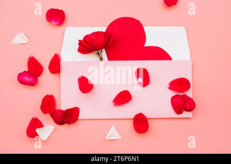 Scatola con fiore di carta a cuore vicino ai petali Foto Stock