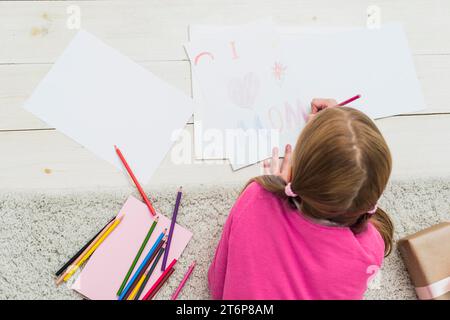 Bambina che disegna amo amo la carta della mamma Foto Stock