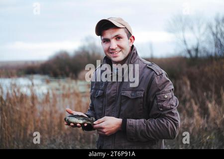 Ritratto felice pescatore che tiene in mano il pesce Foto Stock