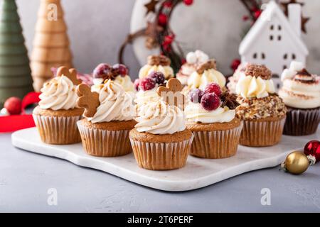 Varietà di cupcake natalizi con pan di zenzero, mirtillo rosso zuccherato e noci pecan candite pronte per essere regalate Foto Stock