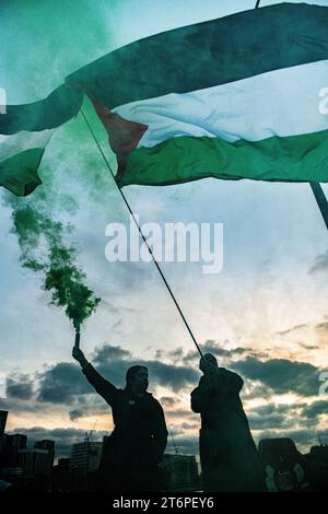 Londra, Regno Unito. 11 novembre 2023. I razzi partono sul Vauxhall Bridge al crepuscolo mentre i sostenitori della Palestina marciano attraverso Londra verso l'ambasciata degli Stati Uniti. Foto Stock