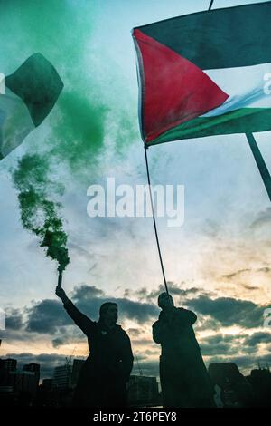 Londra, Regno Unito. 11 novembre 2023. I razzi partono sul Vauxhall Bridge al crepuscolo mentre i sostenitori della Palestina marciano attraverso Londra verso l'ambasciata degli Stati Uniti. Foto Stock