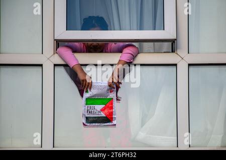 Londra, Regno Unito. 11 novembre 2023. Una bambina impicca il suo disegno ai 300.000 sostenitori pro Palestina che marciano attraverso Londra Foto Stock