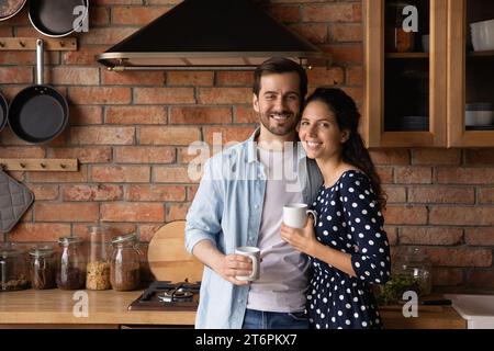 Ritratto di famiglia felice giovane coppia che beve caffè in cucina Foto Stock
