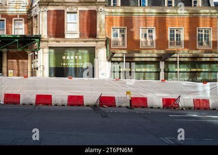 Harts of Smithfield, parte di Smithfield Market, Londra, si trova dietro le barriere di costruzione durante la riqualificazione degli edifici del mercato generale Foto Stock