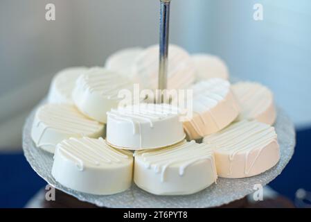 La torre dei cupcake glassati alla vaniglia al bar dessert durante il matrimonio Foto Stock