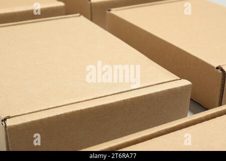 Molte scatole di cartone su sfondo bianco, primo piano. Imballaggio di merci Foto Stock