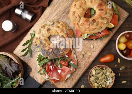 Gustosi panini con bagel su un tavolo di legno, piatti Foto Stock