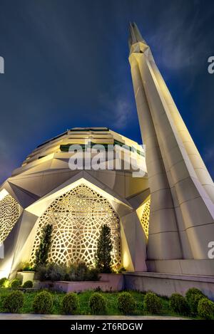 Moschea di Facoltà di Teologia, Università di Marmara, illuminata in modo radioso sullo sfondo di un sereno cielo notturno, con un imponente minareto che raggiunge il cielo, Uskudar, Istanbul, Turchia Foto Stock