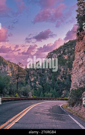 Tranquillo viaggio al tramonto attraverso lo splendido paesaggio montano con strade e alberi in questo viaggio lungo l'autostrada costruita in America Foto Stock