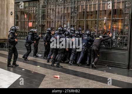 Si vedono agenti di polizia regionali che resistono alla spinta dei manifestanti che tentano di entrare nella stazione francese di Barcellona durante la manifestazione. Circa 7.500 persone hanno manifestato nel centro di Barcellona per dimostrare il loro sostegno e solidarietà al popolo palestinese, respingendo il genocidio delle forze armate israeliane. La manifestazione si è conclusa con l'occupazione temporanea della stazione di Francia, dove la polizia regionale è intervenuta per sfrattarla. Foto Stock