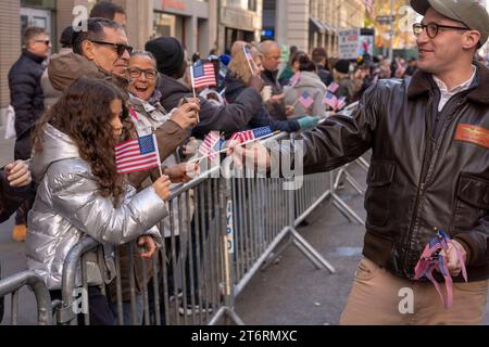 11 novembre 2023, New York, New York, Stati Uniti: (NEW) Veteran&#39;s Day Parade tenutasi a New York City. 11 novembre 2023, New York, New York, USA: Un partecipante distribuisce la bandiera agli spettatori nell'annuale Veterans Day Parade dell'11 novembre 2023 a New York City. Centinaia di persone hanno percorso la 5th Avenue per assistere alla più grande parata del Veterans Day degli Stati Uniti. Questo evento di quest'anno comprendeva veterani, soldati attivi, agenti di polizia, vigili del fuoco e dozzine di gruppi scolastici che partecipavano alla sfilata che onora gli uomini e le donne che hanno servito e sacrificato per il paese. (Credito: M10s / Foto Stock