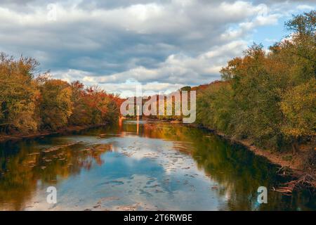 Alberi colorati lungo le rive del fiume Monocacy e un ponte ferroviario sullo sfondo. Frederick County. Maryland. USA Foto Stock