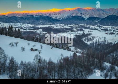 Splendido scenario invernale all'alba con alte montagne innevate. Ammirevole alba sulle montagne innevate, Piatra Craiului, Carpazi, Foto Stock