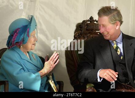 Foto datata 11/10/01 della Regina madre che condivide uno scherzo con suo nipote il Principe di Galles, conosciuto come il Duca di Rothesay in Scozia, durante l'inaugurazione di una scultura Aberdeen Angus presso l'Alford Transport Museum. Foto di ogni anno della vita del re sono state compilate dall'agenzia di stampa PA per celebrare il 75° compleanno di re Carlo III. Data di emissione: Domenica 12 novembre 2023. Foto Stock