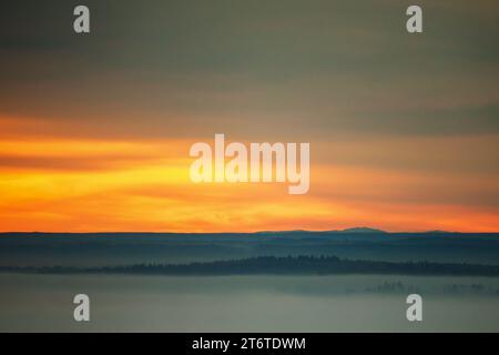 12 novembre 2023, Baden-Württemberg, Unlingen: Vista al mattino, poco dopo l'alba sull'alta Svevia. Il cielo diventa rossiccio solo per un breve periodo prima che la fitta nebbia entri. Foto: Thomas Warnack/dpa Foto Stock