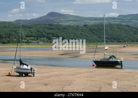 Le piccole barche a vela si siedono sulla sabbia e aspettano che arrivi la marea, ad Abersoch, nel Galles occidentale, Regno Unito Foto Stock