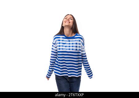 la bella bruna sottile con capelli lisci è vestita con abiti da marinaio a righe blu Foto Stock