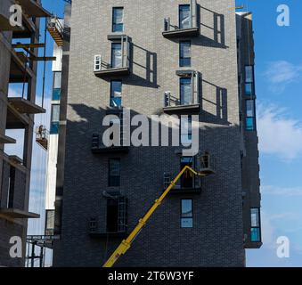Lavori edili di finitura all'aperto. Lavori di costruzione di gru e balconi Foto Stock