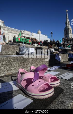 Un paio di scarpe si siede sui gradini sotto la Galleria Nazionale, accanto a loro sono i nomi dei bambini uccisi a Gaza. Le famiglie XR hanno organizzato la protesta per illustrare la morte di bambini a Gaza. Chiedono un immediato cessate il fuoco nella guerra tra Israele e Hamas. Migliaia di bambini sono stati uccisi da quando Israele ha intrapreso azioni di rappresaglia contro Hamas dopo aver ucciso oltre 1000 israeliani e preso 220 ostaggi. Foto Stock