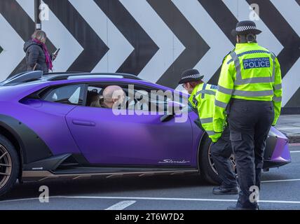 Gli agenti della polizia metropolitana controllano i documenti di un autista di super auto, Londra, Regno Unito. Foto Stock