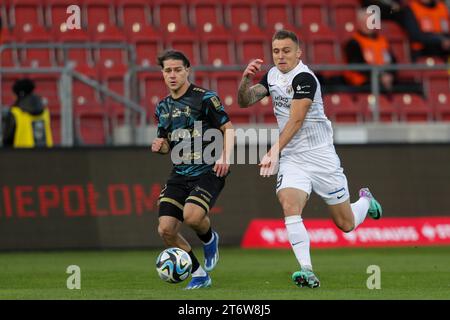 Leonardo Koutris di Pogon Szczecin (L) e Artur Siemaszko di Puszcza Niepolomice (R) in azione durante la partita di calcio polacca PKO Ekstraklasa League 2023/2024 tra Puszcza Niepolomice e Pogon Szczecin allo Stadio Cracovia. Punteggio finale; Puszcza Niepolomice 0:2 Pogon Szczecin. (Foto di Grzegorz Wajda / SOPA Images/Sipa USA) Foto Stock