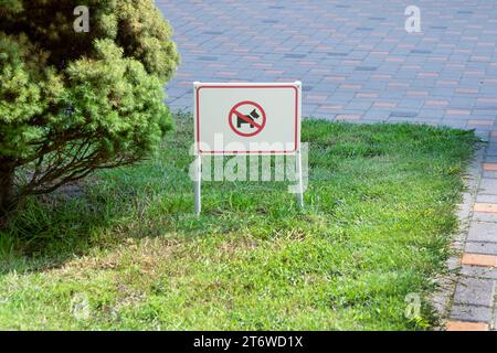 Puntatore sul prato con erba verde. Banner testo cane camminare è vietato bacheca informativa. Ucraina, Kiev - 6 luglio 2023 Foto Stock