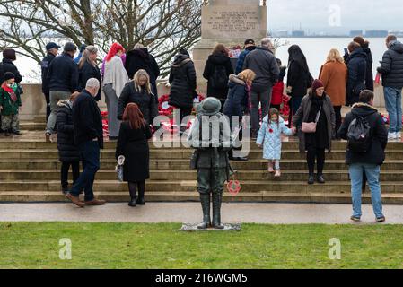 Clifftown Parade, Southend on Sea, Essex, Regno Unito. 12 novembre 2023. Un Remembrance Day Service ebbe luogo presso il Southend War Memorial progettato da Sir Edwin Lutyens sopra il lungomare di Southend on Sea. Una figura di bronzo di un “Tommy” britannico è stata aggiunta per celebrare il centenario della fine della prima guerra mondiale. Sono state posate molte ghirlande Foto Stock