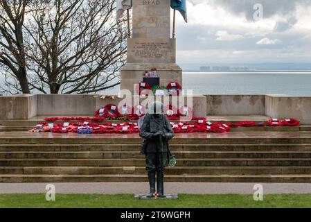 Clifftown Parade, Southend on Sea, Essex, Regno Unito. 12 novembre 2023. Un Remembrance Day Service ebbe luogo presso il Southend War Memorial progettato da Sir Edwin Lutyens sopra il lungomare di Southend on Sea. Una figura di bronzo di un “Tommy” britannico è stata aggiunta per celebrare il centenario della fine della prima guerra mondiale. Sono state posate molte ghirlande Foto Stock