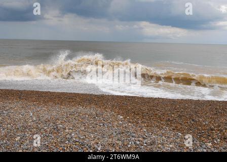 Onde grandi e forti che si infrangono su Shingle Beach con spruzzi di mare che si innalzano sulla costa del Mare del Nord, la mattina dopo Storm Poly. Foto Stock