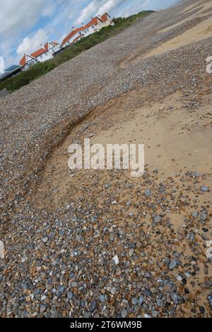 Combinazione di Cliffing e Cusp erosione in spiaggia mista di ciottoli e sabbia, vicino a proprietà residenziali e di affitto per le vacanze. Foto Stock