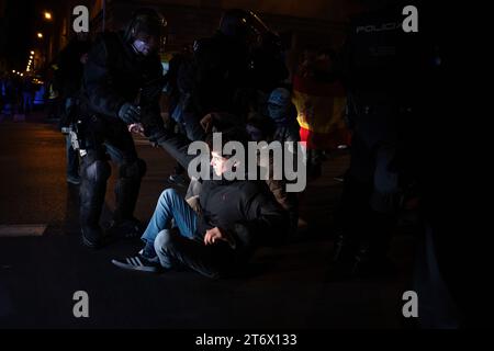 Un poliziotto solleva da terra un manifestante che si era seduto in via Princesa con altre persone durante la protesta. Il nono giorno consecutivo di manifestazioni con pesanti sommosse scontri a Madrid. Più di 1.000 persone hanno lanciato pirotecnici, bottiglie di vetro, pietre e lattine alla polizia e alla stampa nel contesto dell'amnistia per l'ex presidente del governo catalano Carles Puigdemont e l'investitura di Pedro Sanchez, l'attuale presidente della Spagna. (Foto di Ximena Borrazas / SOPA Images/Sipa USA) Foto Stock