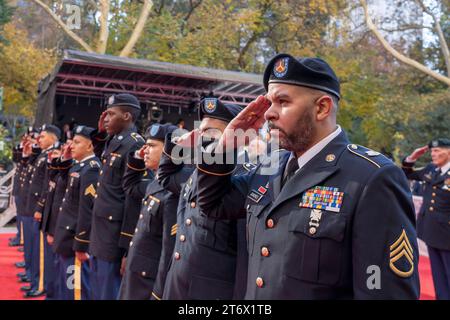 NEW YORK, NEW YORK - 11 NOVEMBRE: Membri del saluto militare durante il gioco dell'inno nazionale all'annuale Veterans Day Parade l'11 novembre 2023 a New York. Centinaia di persone hanno percorso la 5th Avenue per assistere alla più grande parata del Veterans Day degli Stati Uniti. Questo evento di quest'anno comprendeva veterani, soldati attivi, agenti di polizia, vigili del fuoco e dozzine di gruppi scolastici che partecipavano alla sfilata che onora gli uomini e le donne che hanno servito e sacrificato per il paese. Foto Stock