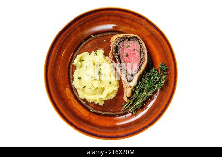 Pasta Wellington di manzo con patate mozzate su un piatto rustico. Isolata, sfondo bianco. Vista dall'alto Foto Stock