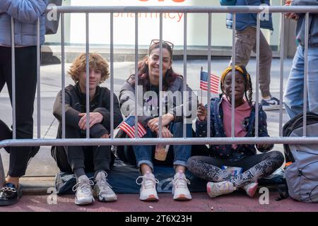 NEW York, NEW YORK - 11 NOVEMBRE: Gli spettatori tengono segno e bandiere nell'annuale Veterans Day Parade dell'11 novembre 2023 a New York City. Centinaia di persone hanno percorso la 5th Avenue per assistere alla più grande parata del Veterans Day degli Stati Uniti. Questo evento di quest'anno comprendeva veterani, soldati attivi, agenti di polizia, vigili del fuoco e dozzine di gruppi scolastici che partecipavano alla sfilata che onora gli uomini e le donne che hanno servito e sacrificato per il paese. Foto Stock