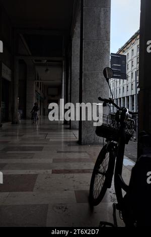 Mantova, Italia - ottobre 2023 - Porchway al limitare di un viale con negozi e gente che passa in una città italiana al tramonto Foto Stock