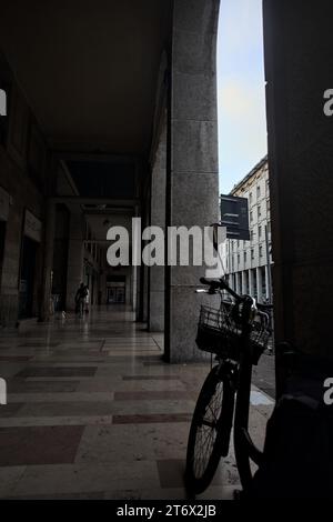 Mantova, Italia - ottobre 2023 - Porchway al limitare di un viale con negozi e gente che passa in una città italiana al tramonto Foto Stock