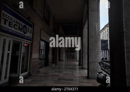 Mantova, Italia - ottobre 2023 - Porchway al limitare di un viale con negozi e gente che passa in una città italiana al tramonto Foto Stock