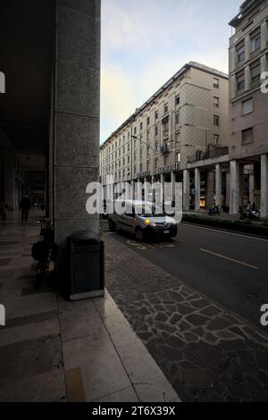 Mantova, Italia - ottobre 2023 - Porchway al limitare di un viale con negozi e gente che passa in una città italiana al tramonto Foto Stock