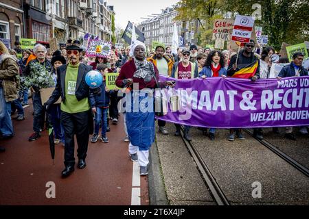 Amsterdam, Paesi Bassi. 12 novembre 2023. AMSTERDAM - partecipanti durante una marcia per il clima e la giustizia. I partecipanti vogliono esortare i politici ad adottare misure contro i problemi che i Paesi Bassi devono affrontare. Parlano della crisi climatica, del razzismo, della biodiversità, della povertà e della crisi abitativa. ANP ROBIN UTRECHT paesi bassi Out - belgio Out credito: ANP/Alamy Live News Foto Stock