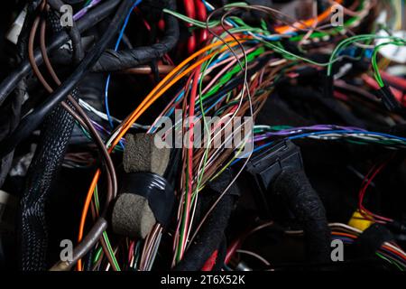 Un cavo di fili opacati di diversi colori con connettori nel cablaggio elettrico della vettura. Linea Internet nel lavoro del provider. Foto Stock