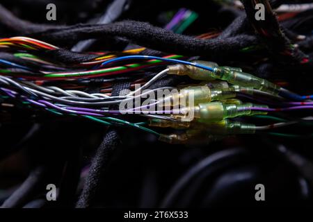 Un cavo di fili opacati di diversi colori con connettori nel cablaggio elettrico della vettura. Linea Internet nel lavoro del provider. Foto Stock