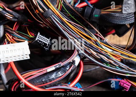 Un cavo di fili opacati di diversi colori con connettori nel cablaggio elettrico della vettura. Linea Internet nel lavoro del provider. Foto Stock