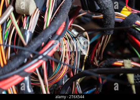 Un cavo di fili opacati di diversi colori con connettori nel cablaggio elettrico della vettura. Linea Internet nel lavoro del provider. Foto Stock