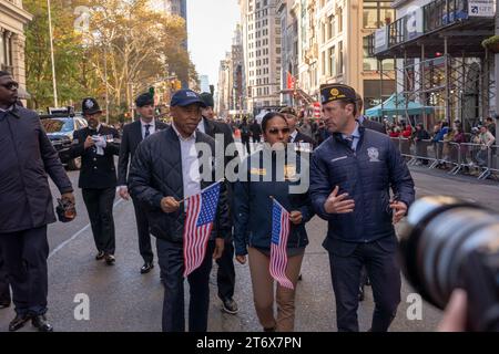 NEW YORK, NEW YORK - 11 NOVEMBRE: Il sindaco di New York Eric Adams, il primo vice Commissario Tania Kinsella e il Commissario per la gestione delle emergenze Zachary Iscol partecipano all'annuale Veterans Day Parade l'11 novembre 2023 a New York City. Adams ha recentemente fatto sequestrare il suo telefono e iPad dall'FBI mentre indagavano sul finanziamento della campagna nella sua amministrazione. Centinaia di persone hanno percorso la 5th Avenue per assistere alla più grande parata del Veterans Day degli Stati Uniti. L'evento di quest'anno comprendeva veterani, soldati attivi, agenti di polizia, vigili del fuoco e decine di gruppi scolastici che partecipavano alla parata Foto Stock